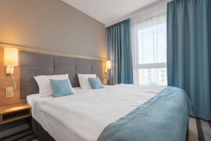 米兹多洛杰Bel Mare Resort的一张位于酒店客房的大床,设有大窗户
