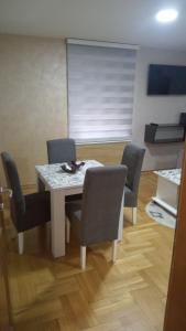 兹拉蒂博尔Apartman Dinić Zlatibor的一间带桌子和四把椅子的用餐室