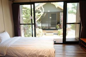 小琉球岛小杉丘民宿的一间卧室设有一张床和一个大窗户