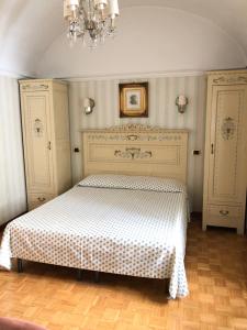 都灵Ai Savoia B&B - Guest House的一间带床的卧室,位于一个吊灯的房间