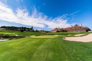 马德里Spectacular villa with pool in Madrid and privacy的一座高尔夫球场,后方是一座房子