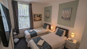 伯恩茅斯塞西尔考特酒店的小房间设有两张床和窗户