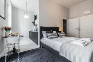 波兹南SERENITY Residence - Old Town Poznan by Friendly Apartments的一间卧室配有一张床和一张桌子及椅子