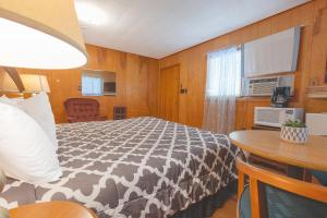 Conneaut Lake ParkParkside Motel by OYO Meadville Conneaut Lake的一间卧室配有一张带黑白色棉被的床