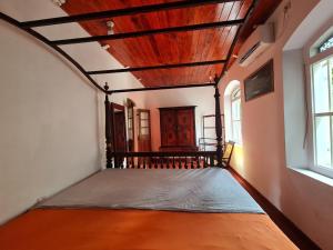 希克杜沃Hill Side Kings Villa (Colonial Bungalow)的一间设有床铺的卧室,位于带窗户的房间内