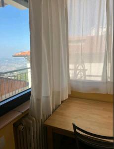 圣马力诺Above The Sky - Flying Apartment的客房设有桌子和享有美景的窗户。