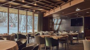 科帕奥尼克Grey Hotel Kopaonik的用餐室设有桌椅和窗户。