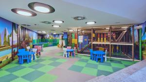 科帕奥尼克Grey Hotel Kopaonik的儿童游戏室,配有色彩缤纷的地板和桌椅