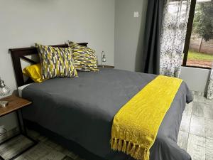 理查兹湾Palm Tree Cottage Felixton的一间卧室配有一张黄色毯子床