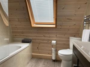 LeightonRabbit Glamping Pod School House Farm的浴室配有卫生间、浴缸和水槽。