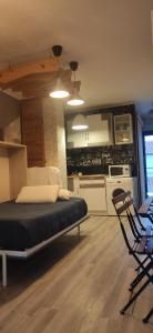 多列毛利诺斯SALTILLO ALTO WHITE STUDIO的一间卧室配有一张床和一把椅子,一间厨房