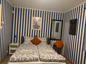BurträskFin Villa nära insjön Burtäsket的一间卧室配有一张蓝色和白色条纹的床