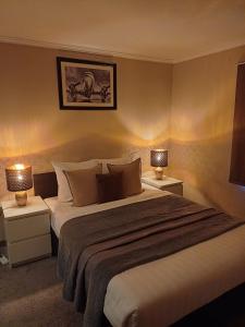 沙勒罗瓦机场公园酒店的一间卧室配有一张大床和两盏灯