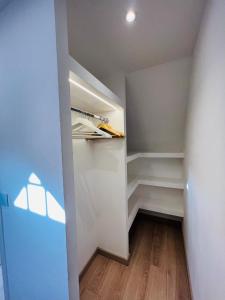 Ris-OrangisSuperbe appartement avec jardin et parking privé的步入式衣柜,配有白色的墙壁和木地板