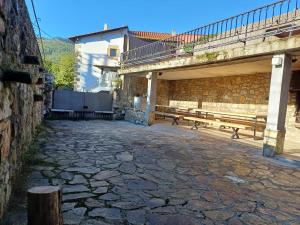 AdinoCasa Magdalena: mar y montaña的一条石街,有长椅和桥梁