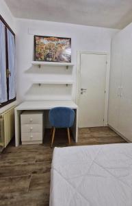 威尼斯Ca' Fontego的一间卧室配有书桌和蓝椅