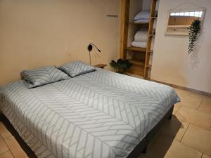 洛布Gîte citadin de l'Entreville的卧室内的一张床铺,配有白色床单