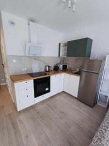 克拉科夫Wielicka Apartment 3的厨房配有白色橱柜和不锈钢冰箱