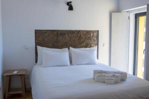 马尔旺Casa do Vale的一张带白色床单的床和两个盒子