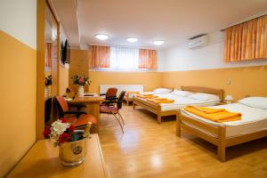 拉多夫吉卡培恩斯安科瓦奇酒店的带三张床和桌椅的房间