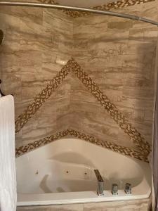 卡纳布Crazy Horse - APT 1的带浴缸的浴室和石墙