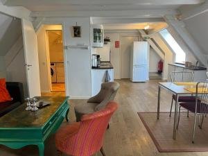 奥本罗Skovridergaardens Ferielejligheder的客厅配有桌椅和冰箱。