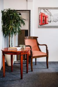 克拉科夫Aparthotel Maargick的茶几和盆栽旁边一张桌子和一把椅子