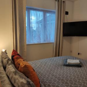 科尔切斯特Ratcliffe Apartment的一间卧室设有一张大床和大窗户