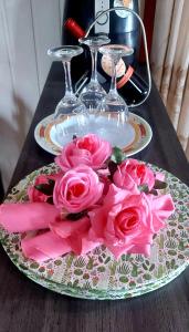 卡内拉Casa em Canela RS的桌上的粉红色玫瑰板,玻璃杯