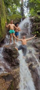 埃尔扎伊诺Cabaña la Hamaca Grande un encuentro con la naturaleza的站在瀑布顶上的三个男人