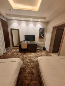 麦地那فندق دان البلاتيني的酒店客房设有两张床和电视。