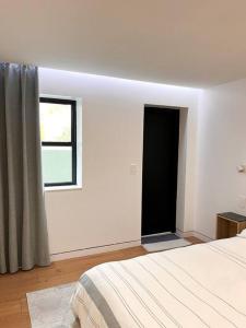 布鲁克林New Cozy Modern Minimalist Stay in Brooklyn at Rem-Casa的白色的客房设有床和窗户。