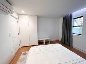 布鲁克林New Cozy Modern Minimalist Stay in Brooklyn at Rem-Casa的白色的卧室设有一张大床和一个窗户