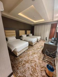 麦地那فندق دان البلاتيني的酒店客房带两张床和一张桌子,还有一间房间带两张