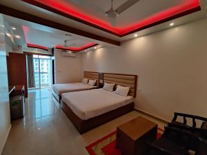 库克斯巴扎Hotel Sea Moon的一间卧室设有两张床和红灯