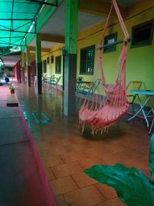 伊瓜苏港RESIDENCIAL LOS AMIGOS的红色吊床挂在带桌椅的建筑中