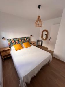 拉雷斯廷加Apt La Chalana by El Hierro Stay的卧室配有一张带黄色枕头的大型白色床。