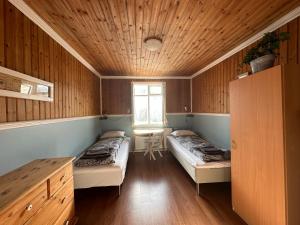 雷扎尔菲厄泽Tærgesen Guesthouse的木墙客房的两张床