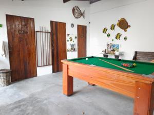阿奎拉兹Pousada Alecrim的客厅设有台球桌,客厅设有游泳池