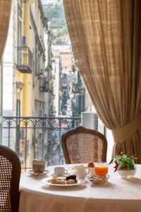 那不勒斯Napolit'amo Hotel Principe的窗口顶上一张桌子,上面有盘子的食物