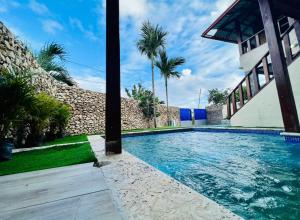 卡布雷拉Villa Loma alta Cabrera的棕榈树建筑前的游泳池