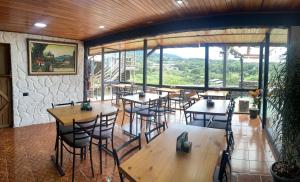 蒙泰韦尔德哥斯达黎加俯瞰海景住宿加早餐旅馆的一间设有桌椅的餐厅,位于带窗户的房间内