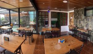 蒙泰韦尔德哥斯达黎加俯瞰海景住宿加早餐旅馆的一间空餐厅,配有木桌和椅子