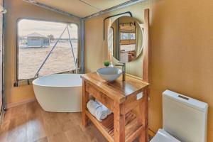 BroadwaterWillow Wood Glamping Retreat的带浴缸、水槽和镜子的浴室
