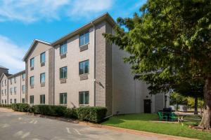 罗阿诺克Quality Inn & Suites Roanoke - Fort Worth North的公寓大楼前面有一棵树