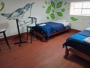 查查波亚斯DEJAVU的卧室配有两张床,墙上有一只鸟