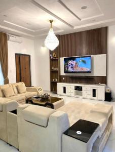 莱基Urban Retreat Luxury Shortlet Apartment Lekki Lagos的带沙发和电视的客厅
