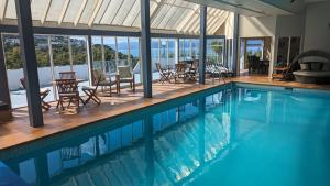 惠灵顿Harbour Lodge Wellington的房屋内一个带桌椅的游泳池