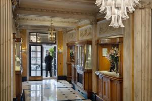 伦敦Grand Residences by Marriott - Mayfair-London的手持吊灯走进走廊的人