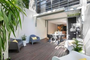 布里斯班The Sun Catcher - A Trendy South Brisbane Terrace的一个带桌椅的庭院和一座建筑